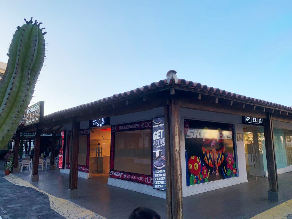 vinilos impresos y cajas de luz en la entrada de una tienda de ropa deportiva