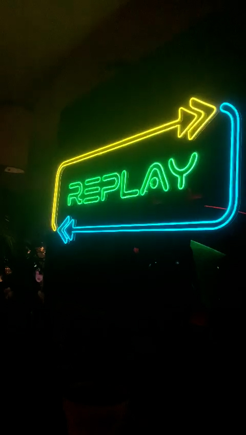 Letrero de NeonFlex Replay con flechas de colores